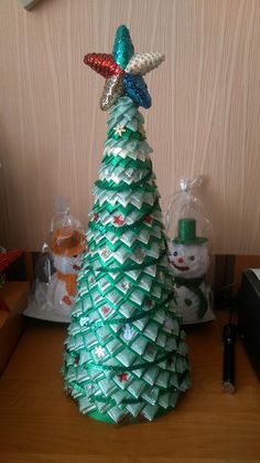 a christmas tree made out of beer bottle caps with a starfish decoration on top