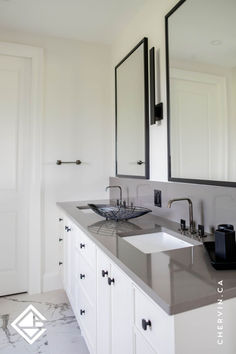 a bathroom with two sinks and mirrors on the wall