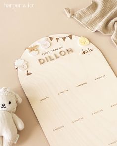 a baby's birth announcement with a teddy bear and bib laying next to it