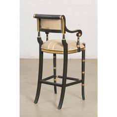 an antique black and gold painted bar stool with caned backrests, in the style of louis ii