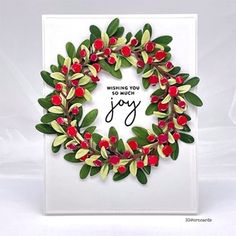 a handmade christmas card with red berries and green leaves on it, saying wishing you so much joy