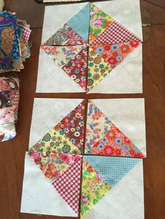 four blocks are laid out on the table to be made into quilted wall hangings