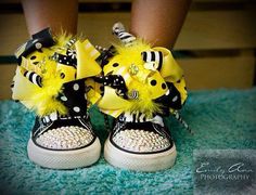 a pair of shoes with yellow and black bows