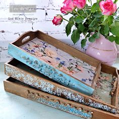 three wooden boxes with flowers in them sitting on a table next to a potted plant