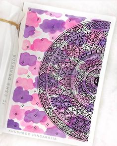 a card with an intricate design in purple, pink and white colors on the front