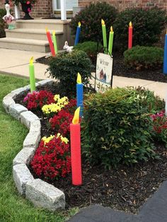 some colorful candles are in a flower bed