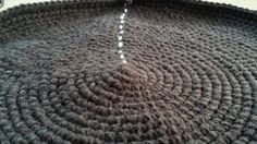 a crocheted rug is shown on the floor, with a hook in it