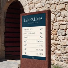 a sign in front of a stone building with an arched doorway that says la palma