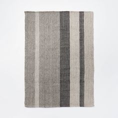 a gray and black striped rug on a white background