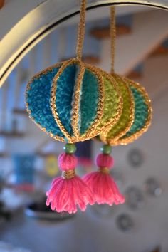 three tassels hanging from a metal pole in front of a clock and ceiling fan