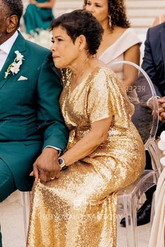 a man and woman sitting next to each other at a formal event in gold sequins