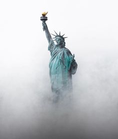 the statue of liberty is surrounded by fog