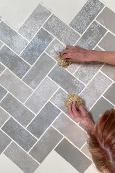 a woman is cleaning the floor with a sponge