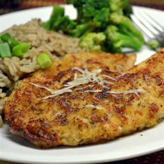 a white plate topped with meat, rice and broccoli next to a fork