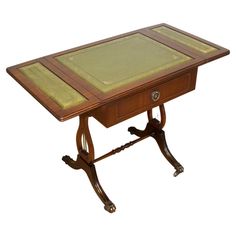 a small wooden table with a green cloth on top