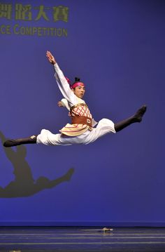 a man is performing on stage with his legs in the air