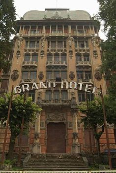 an old building with the word grand hotel on it's front and stairs leading up to its entrance