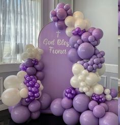 purple and white balloons are arranged in the shape of an arch with words on it