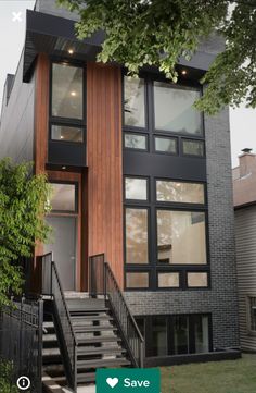 a modern home with stairs leading up to the front door and second story window above it