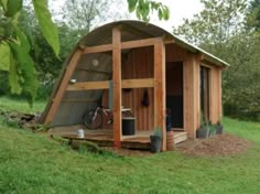 a small wooden structure with a bicycle parked in it