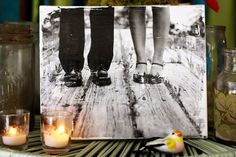 two people standing next to each other on a wooden floor with candles in front of them