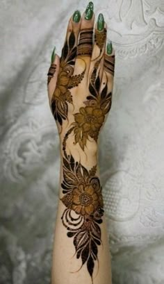 a woman's hand with hennap and flowers painted on the palm,