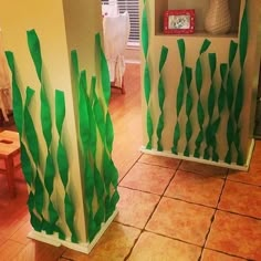 some very pretty green decorations in the corner of a room with tile floor and walls