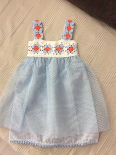 a blue and white dress sitting on top of a bed