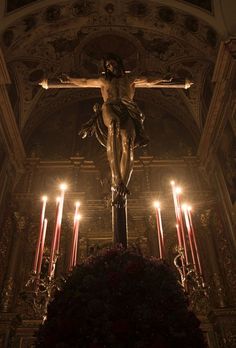 the crucifix is surrounded by candles and flowers