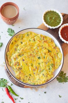 an omelet on a plate with sauces next to it