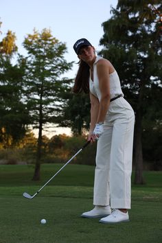 a woman is playing golf on the green