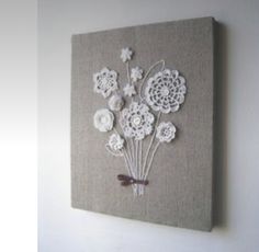 a canvas with white flowers on it hanging on the wall next to a light switch