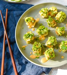 a plate with broccoli on it next to chopsticks