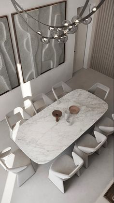 a dining room table and chairs in front of two large mirrors with lights hanging from them