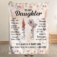 a blanket with the words to my daughter and flowers on it in front of a white wall