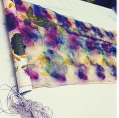 a tie - dyed piece of cloth is sitting on a table with some string attached to it