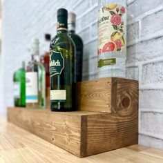 bottles of alcohol sit on top of a wooden shelf