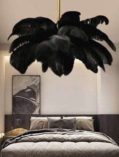 a bedroom with a large bed and black feathers hanging from the ceiling