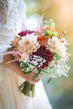 a bride holding a bouquet of flowers in her hands