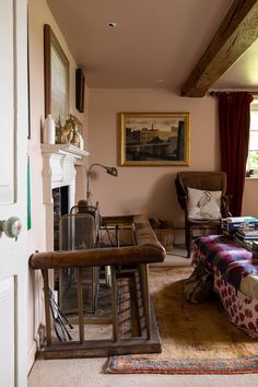 a living room filled with furniture and a painting hanging on the wall over a fire place