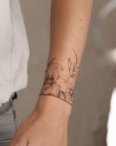 a woman's arm with a flower tattoo on the left side of her wrist