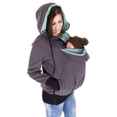 a woman is wearing a hoodie and holding a mitt