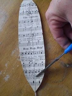 a person cutting up sheet music paper with scissors