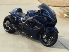 a blue motorcycle parked on top of a sidewalk