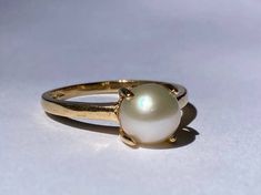 Beautiful single pearl ring in a claw mount from the late Art Deco era in 14K yellow gold. This beautiful pearl ring features a very pretty 6.6mm natural pearl mounted in a decorative yellow gold claw mount. The pearl is in excellent condition with lovely luster, and the prongs and ring shank are in mint condition. Ring size 5 1/2 and easily sized up or down several sizes. Ring sizing service available; please see sizing fees listed below. Please allow one week for sizing. One month layaway paym Ring Cathedral Setting, Pearl Ring Design, Vintage Pearl Ring, Pearl Rings Vintage, Late Art, Dream Wedding Ring, Cathedral Setting, 21 Grams