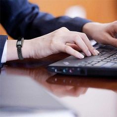 a person typing on a laptop computer at a desk