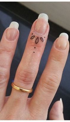 a woman's hand with a ring on it and some nail designs on her fingers