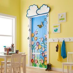 a child's room with yellow walls and blue door decorated with flowers, butterflies and raindrops