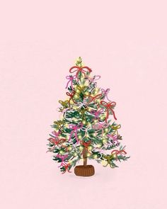 a small christmas tree decorated with ribbons and bows on a pink background for the holiday season