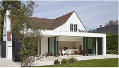 a white house with an open patio and dining area